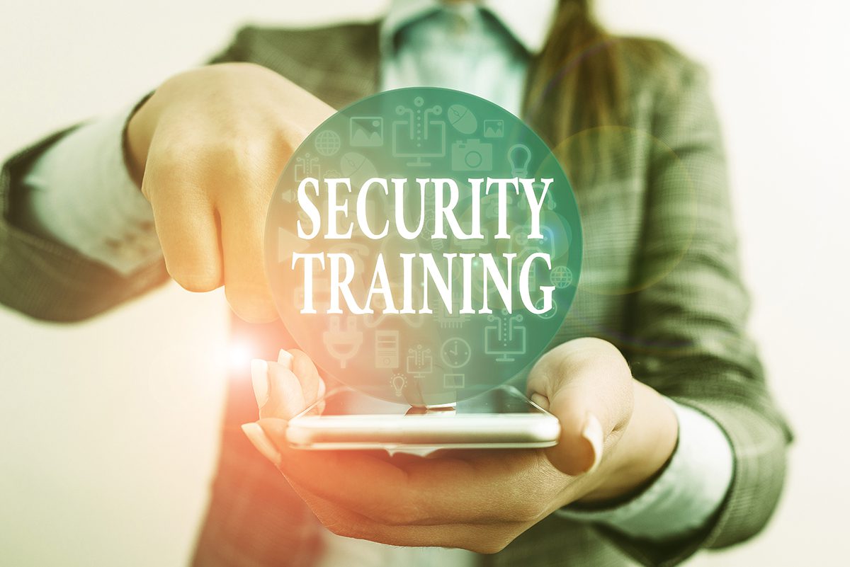 A person in a business suit tapping on their phone with a Security Training button overlay.