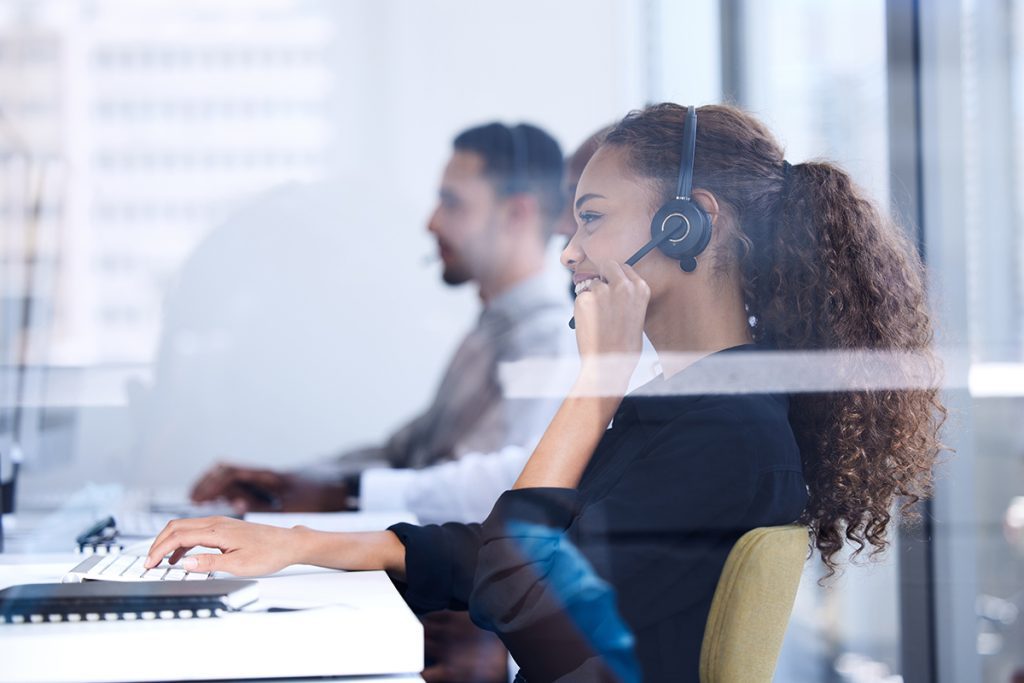 A telephone operator using a VoIP phone headset to speak with customers.